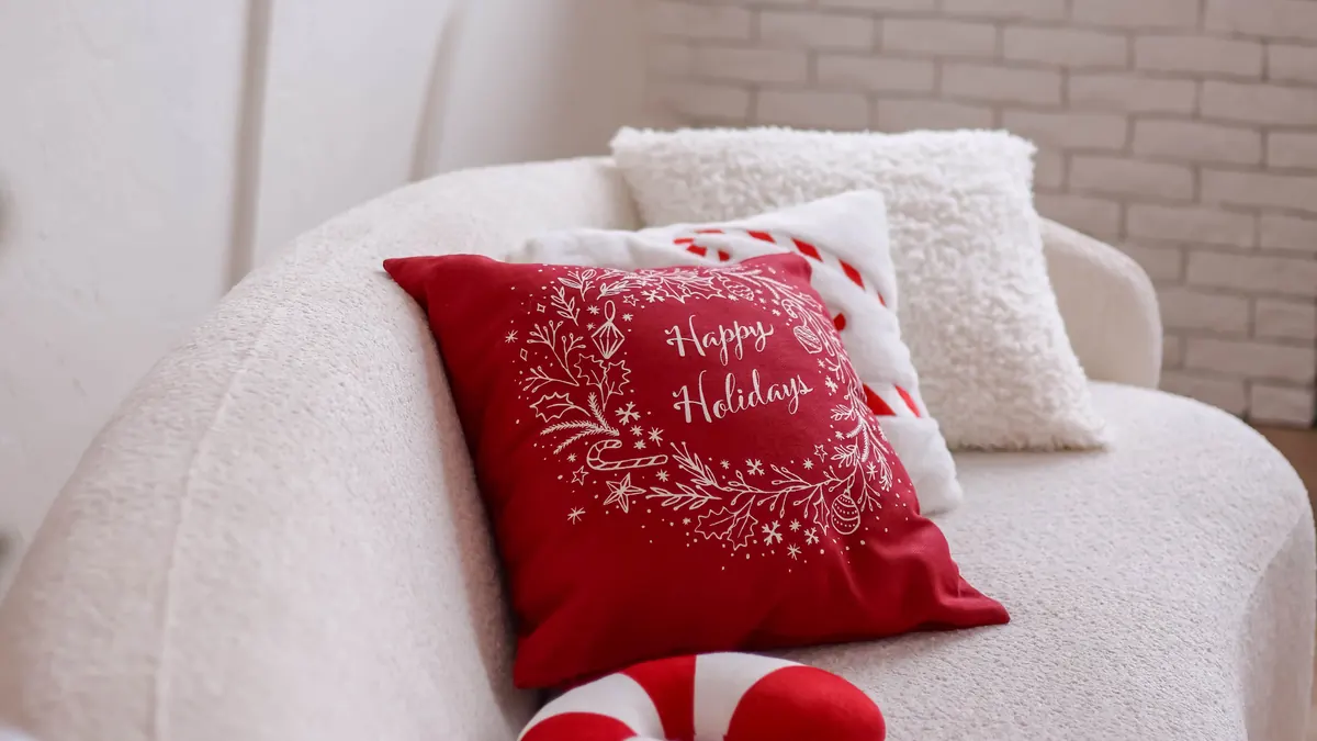 Red and white Christmas throw pillows arranged on a cozy sofa