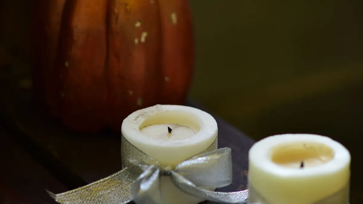 Real pumpkin and two small candles tied with ribbon, a cozy, low-plastic Halloween decor setup